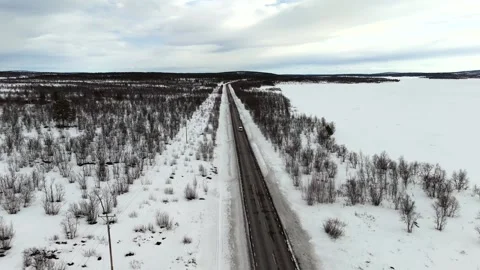 Aerial drone footage capturing capturing a van journey along a snow covered Stock Footage 330376534