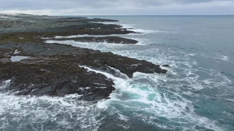 Aerial drone footage capturing waves forcefully hitting a rocky coastline, showc Stock Footage 308933308