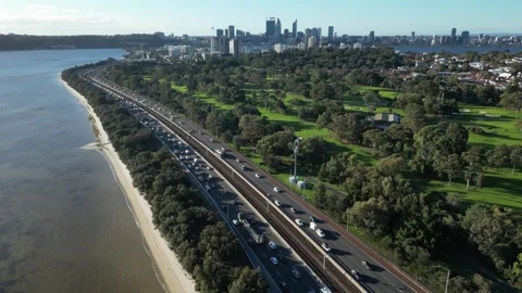 Aerial drone footage of congested highway traffic flow beside parkland and .. Stock Footage 337381222
