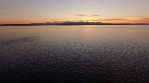 Aerial Drone Footage Flying away from sunset across puget sound waters Stock Footage