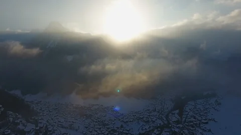 Aerial Drone Footage of fresh snowy mountains with trees in morning light Stock Footage