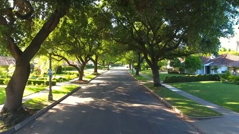 Aerial drone footage going down a Pasadena street during a sunny afternoon Stock Footage 106764992