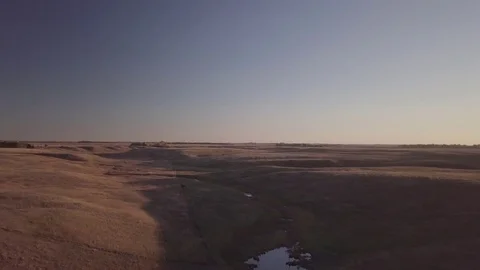 Aerial drone footage over prairie pasture land at sundown in rural North Dakota Stock Footage