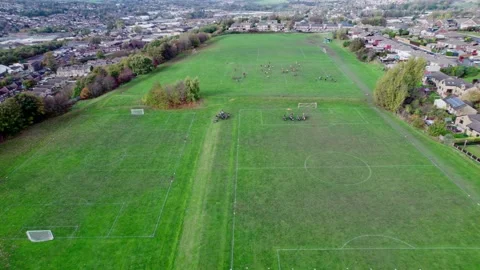 Aerial drone footage of playing fields, football pitch with school children.. Vidéo 235675149