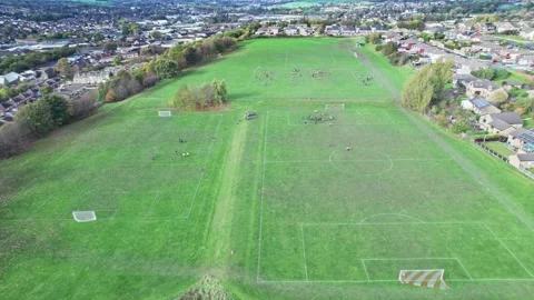 Aerial drone footage of playing fields, football pitch with school children.. Vidéo 235675199