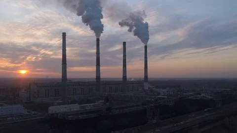 Aerial drone footage of power station chimney during sunset time. Drone is Stock Footage