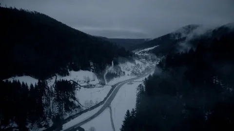 Aerial drone footage of road amidst snow covered mountains, Kniebis, Black Stock Footage