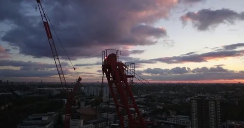 Aerial drone footage of a tower crane and construction worker at sunset. Vídeos de archivo 82002103