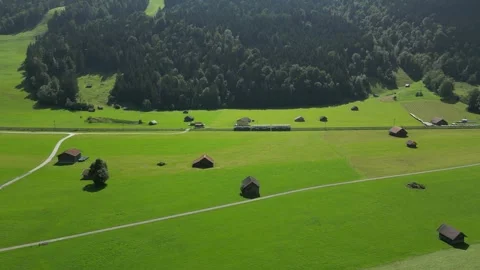 Aerial Drone Footage of Train Passing Through Green Fields Near Zugspitze Stock Footage 296923876