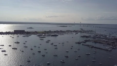 Aerial Drone footage of yacht and boats on water with bridge in the background Stock Footage