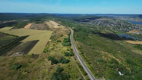 Aerial drone forward flight over country road, fields and village in Moldova Stock Footage 320371012