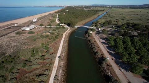Aerial drone forward perspective of a canal next to Praia de Falesia Stock Footage 239462406