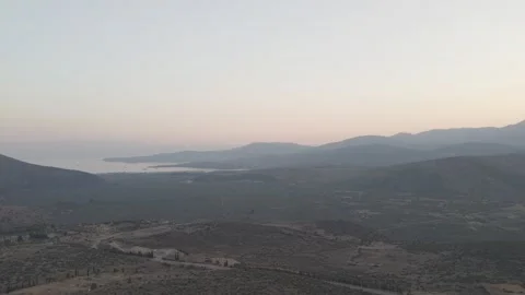 Aerial drone forward shot flying away from the sunset over the sea with Видео 332994065