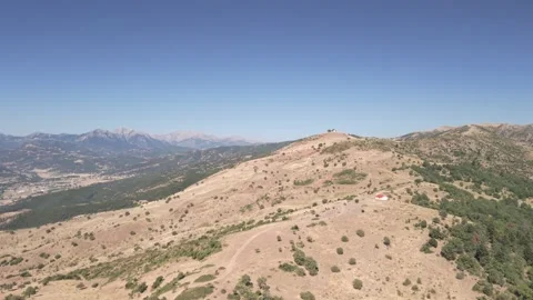 Aerial drone forward shot over green countryside featuring a traditional Greek Vidéo 332985683