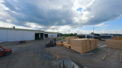 Aerial: Drone Forward Stack Of Lumbers Under Shades On Industrial Landscape Stock Footage 237040297