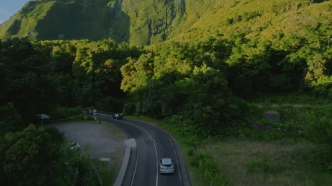 Aerial drone high-angle view of a car driving along a winding road through a Stockbeeldmateriaal 335706620