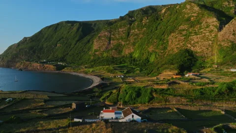 Aerial drone high-angle view of a coastal village with rural houses and farmland 库存影片 335709572