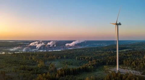 Aerial drone landscape photo of wind turbine rising over forest at sunrise Stock Photos