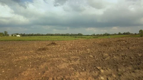 Aerial, drone, low flight over freshly plowed land, working tractor Stock Footage 94570854