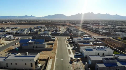 Aerial Drone Move Down New Southwest Subdivision with Mountains and Sun Flare Stock Footage 243656328