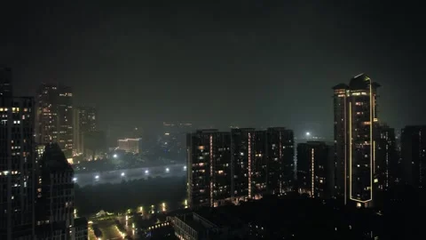 Aerial drone night shot flying towards lit skyscrapers, homes, houses, office Stock Footage 306410341