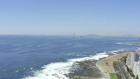 Aerial drone, ocean and waves of beach, shore or coastline with paraglider Stock Footage 258359840