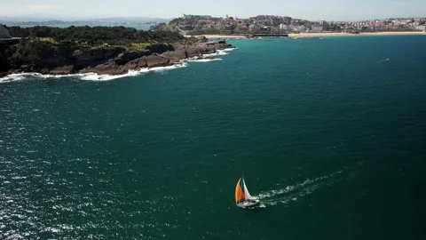 Aerial drone orbit of orange sailboat near Magdalena Peninsula in Santander Stock Footage 237894853