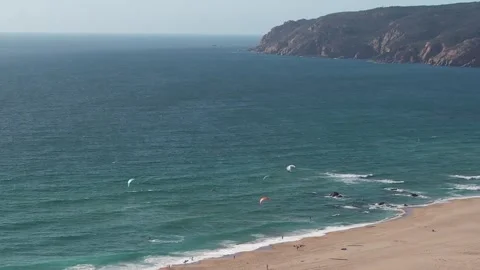 Aerial drone orbit view of Guincho beach with kytesurfers on the water and Cabo Stock Footage 246753052