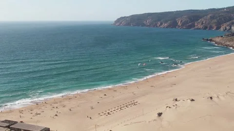 Aerial drone orbit view of Guincho beach with kytesurfers on the water Stock Footage 246753639