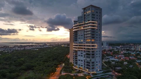 Aerial drone orbiting around illuminated skyscrapers at sunset, Santo Stock Footage 280414579