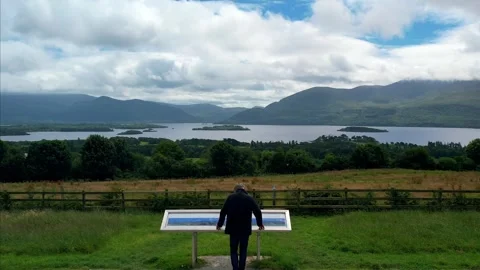 Aerial Drone Over Man at Killarney Lakes Viewing Point, Revealing Valley Stock Footage 301408603