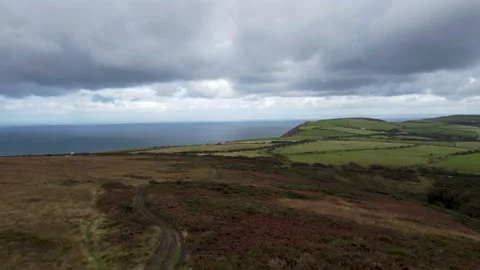Aerial Drone Over Moor Path with Sea Background Grass Fields and Dramatic Sky Stock Footage 162967468