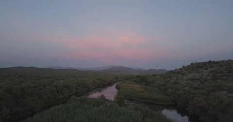 Aerial Drone over River looking at mountains at sunset. Stock Footage