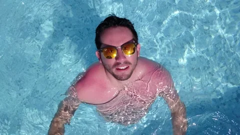 Aerial drone overhead view moving away from a man waving at the camera in the po Video stock 199569739