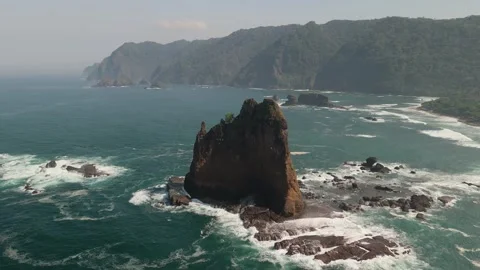 Aerial Drone Pan Across Dramatic Sea Stack and Rocky Coastline Stock Footage 339991508