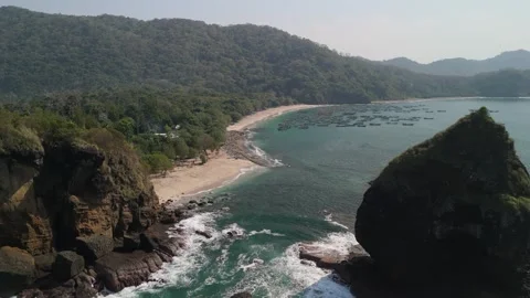 Aerial Drone Pan Across Dramatic Sea Stack and Rocky Coastline Stock Footage 339991556