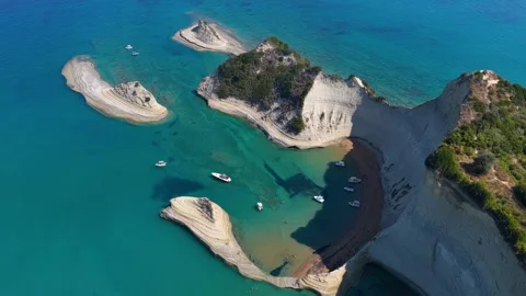 Aerial drone pan of dramatic white cliffs and turquoise sea at Cape Drastis in Stockbeeldmateriaal 345044746