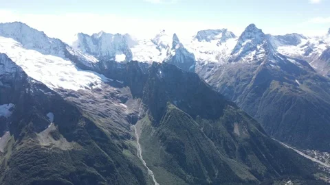 Aerial drone panning shot of sharp mountain peaks and massive glaciers Stock Footage 336957994