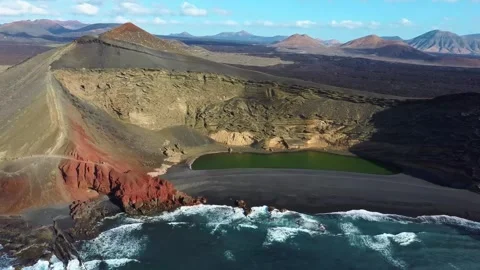 Aerial Drone Panoramic View of Coastline with Red Rocks and a Green Lake Stock Footage 287988859