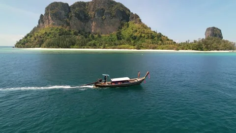 Aerial drone parallel with a tourist at the front of a thai longtail boat Stock Footage 196099554