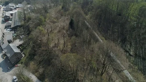 Aerial drone of passenger train through village, residential area Stock Footage 110832567