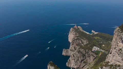 Aerial drone of a path hill crowd of boats sailing in seawater lighthouse Capri Stock Footage 113701839