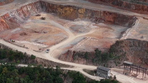 An aerial drone perspective of an active open pit mine featuring heavy Stock Footage 340896872