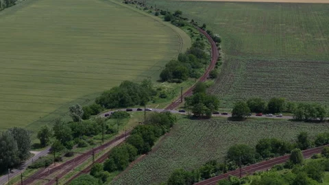 An aerial drone perspective captures a rail line crossing a country road amidst Stock Footage 337471350