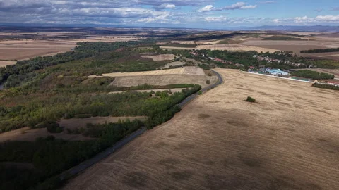 An aerial drone perspective captures the rolling landscape of harvested 스톡 동영상 347823458