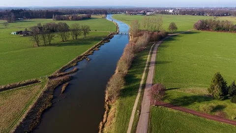 An aerial drone perspective tracking a long, calm river or shipping canal Stockbeeldmateriaal 336406954