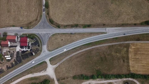 An aerial drone perspective of vehicles driving on a rural highway junction Stock Footage 341405182