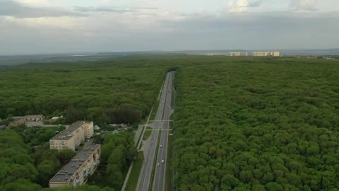 Aerial drone pull-back and rise over forest highway Stock Footage 338004452