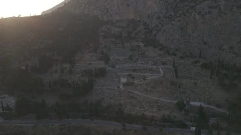 Aerial drone pull back reveal shot of the Temple of Apollo ruins in Delphi Видео 332974995