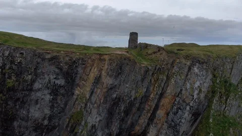 Aerial: drone pull back shot of woman walking on the cliffs //Ireland 库存影片 117441253